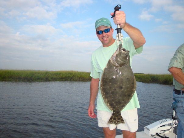 Angler holding a flounder on the boat