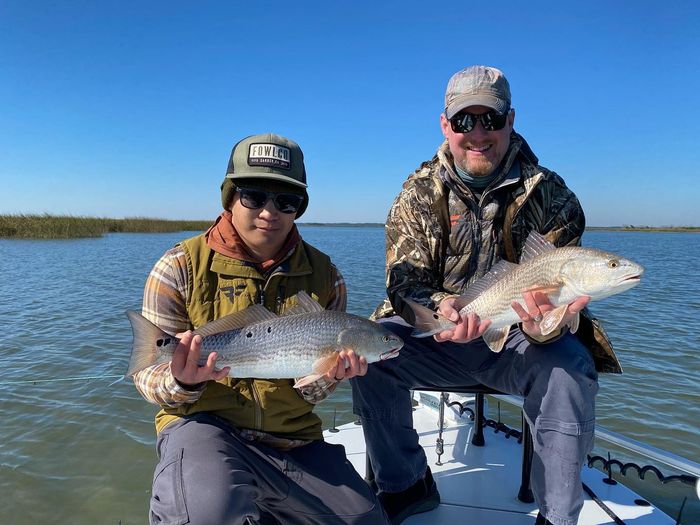Two anglers holding redfish