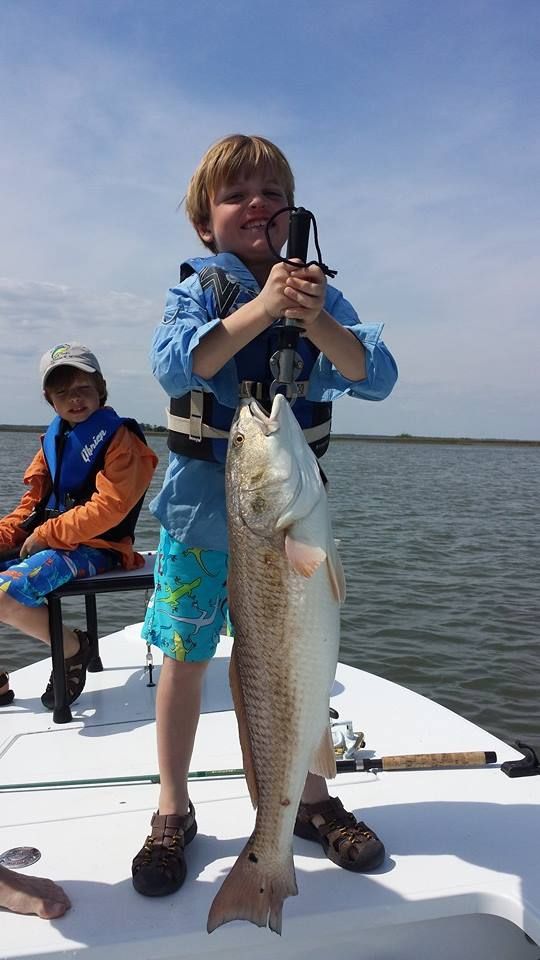 Young angler holding up a redfish